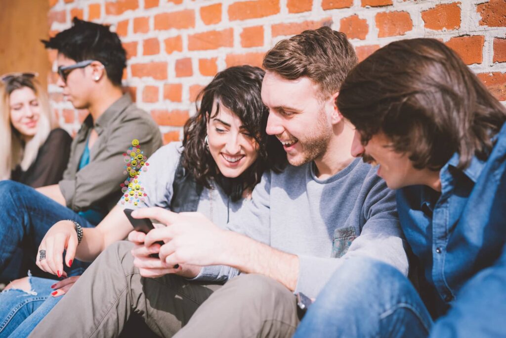 People smiling and looking at mobile phone.